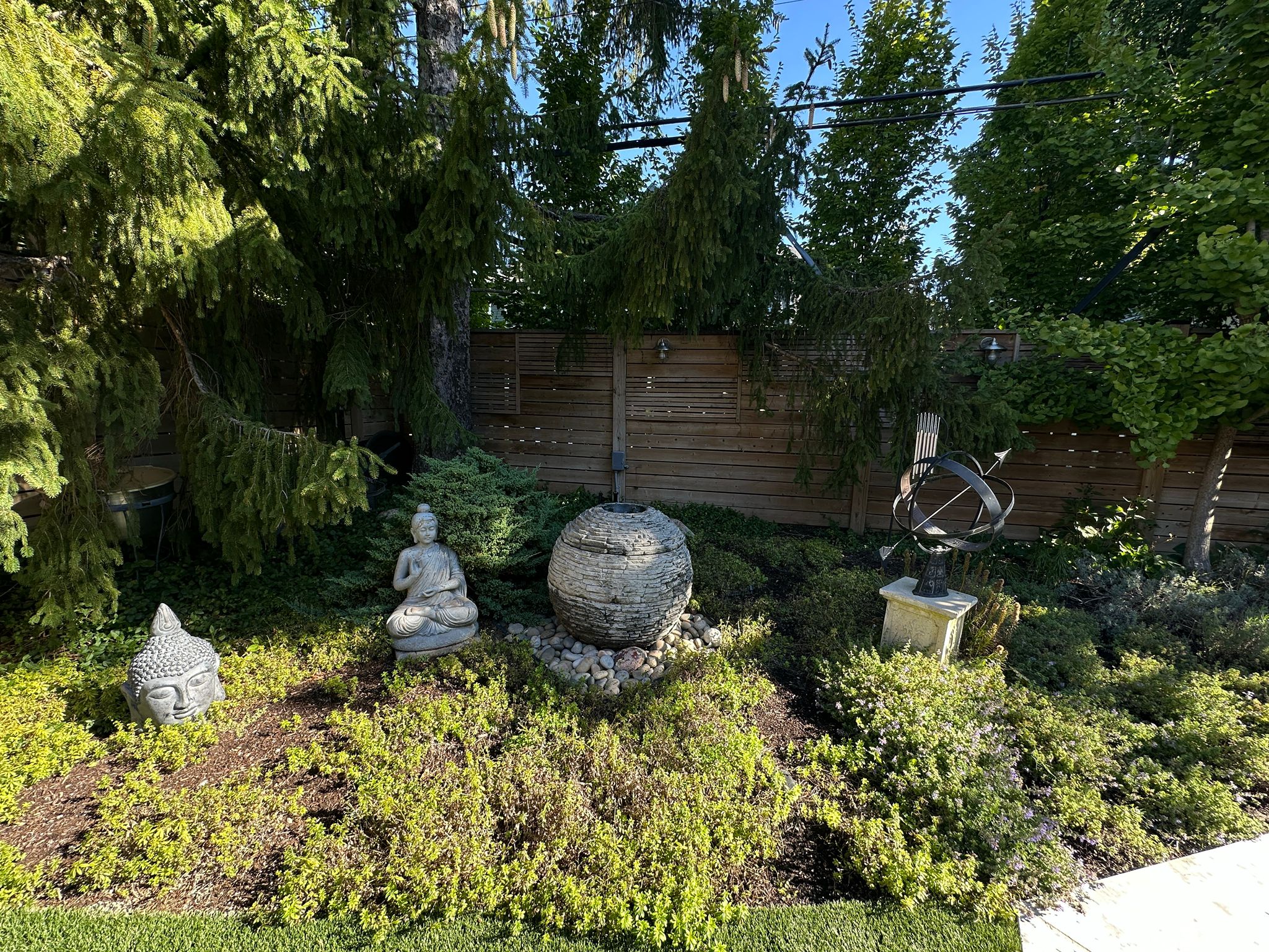 Serene Zen garden with sculptures and greenery.