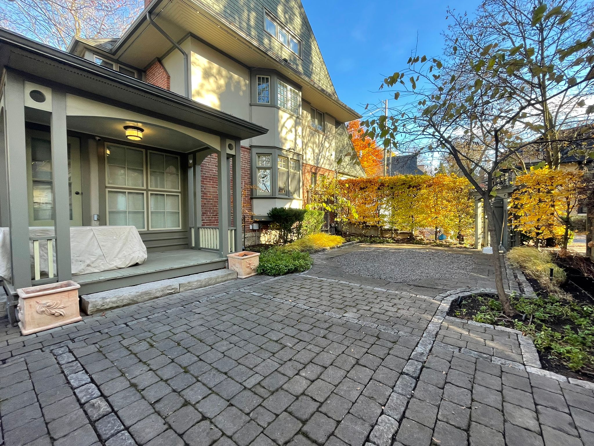 Modern house with paved front yard and trees