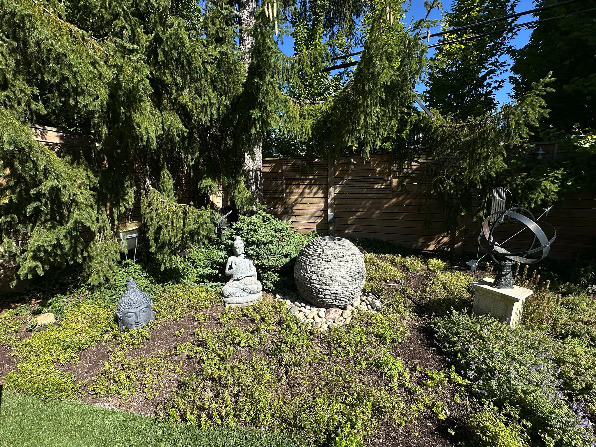 Zen garden with Buddha statues and sculptures.