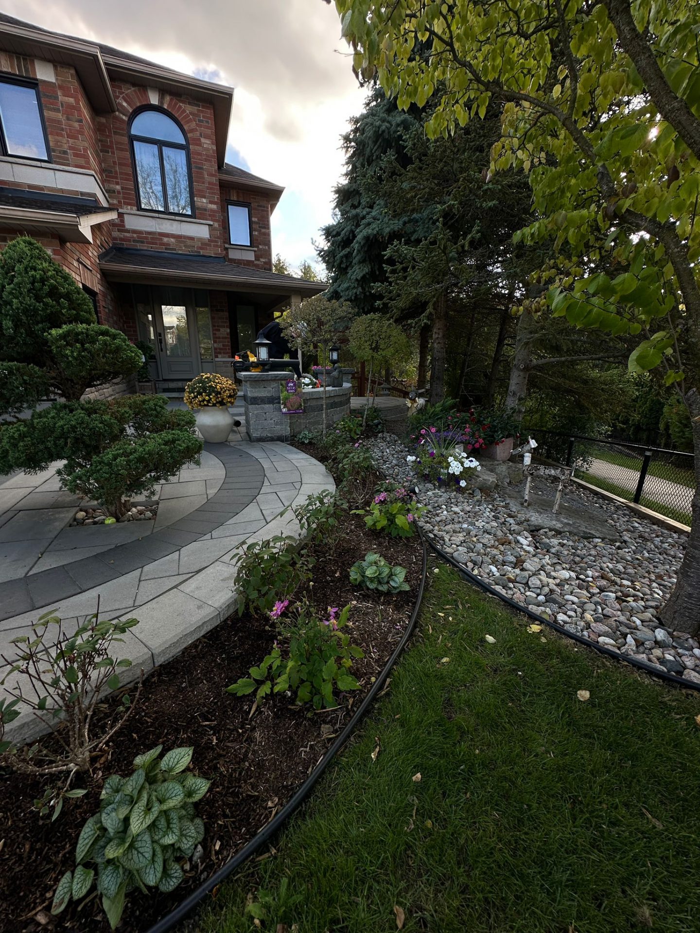 Brick house with garden and patio scene.
