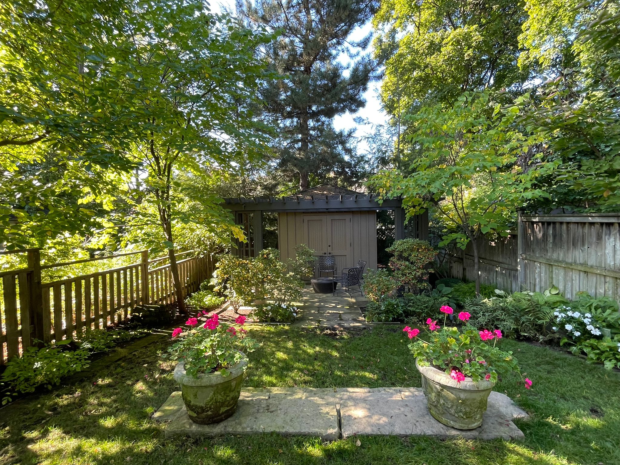 Garden with flowers, trees, and wooden fence