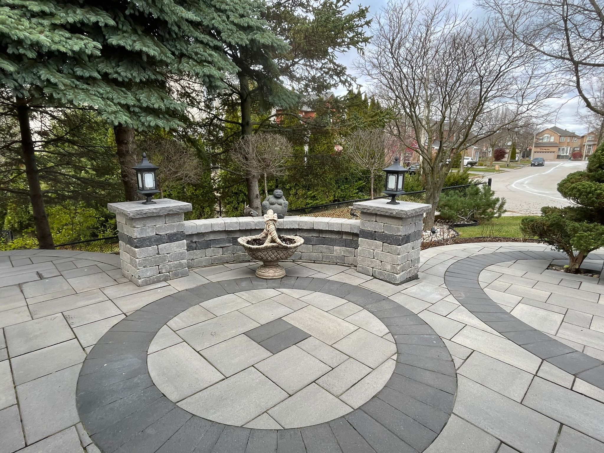 Stone patio with decorative fountain and lanterns.