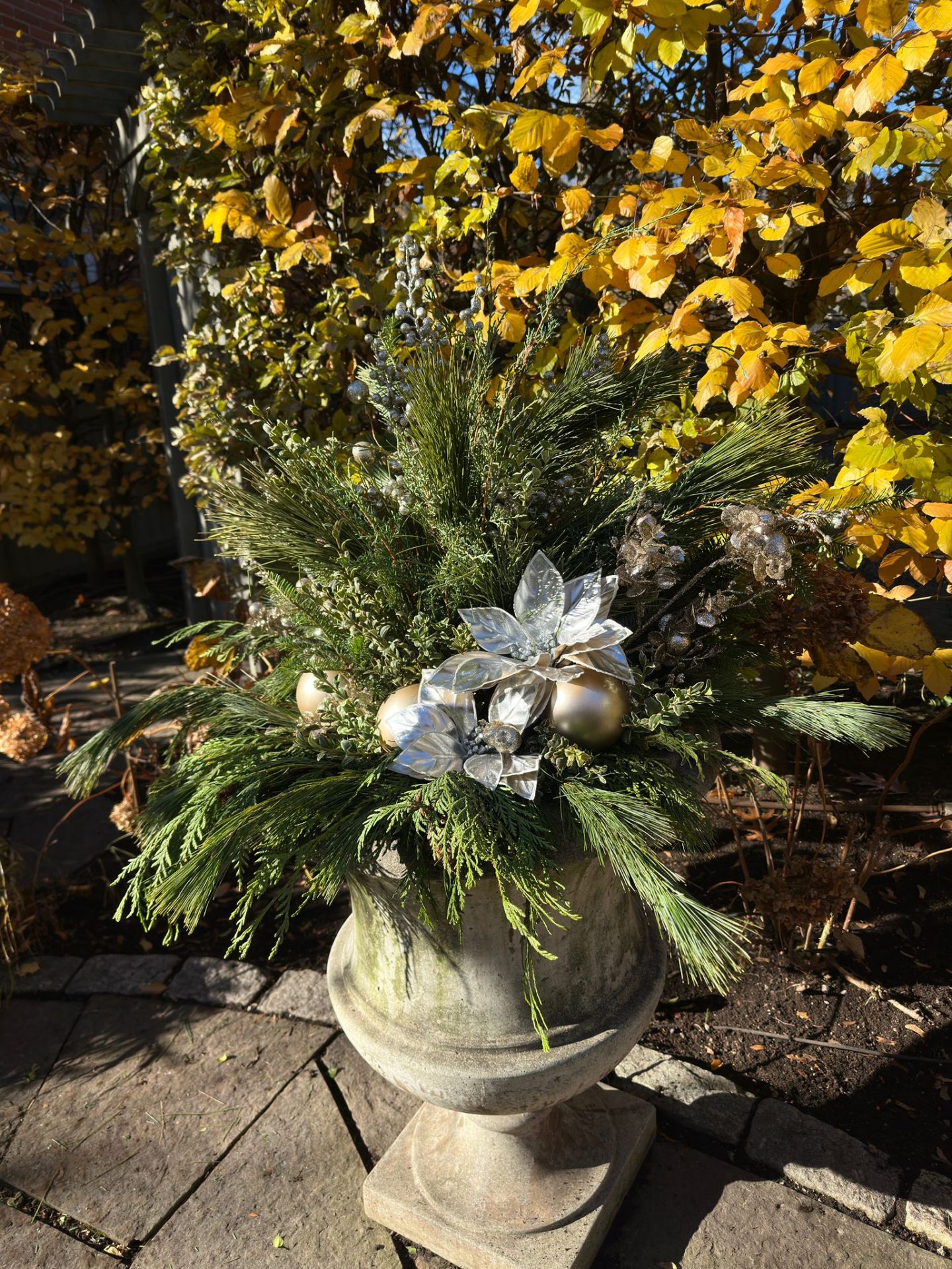 Decorative planter with festive greenery and ornaments.