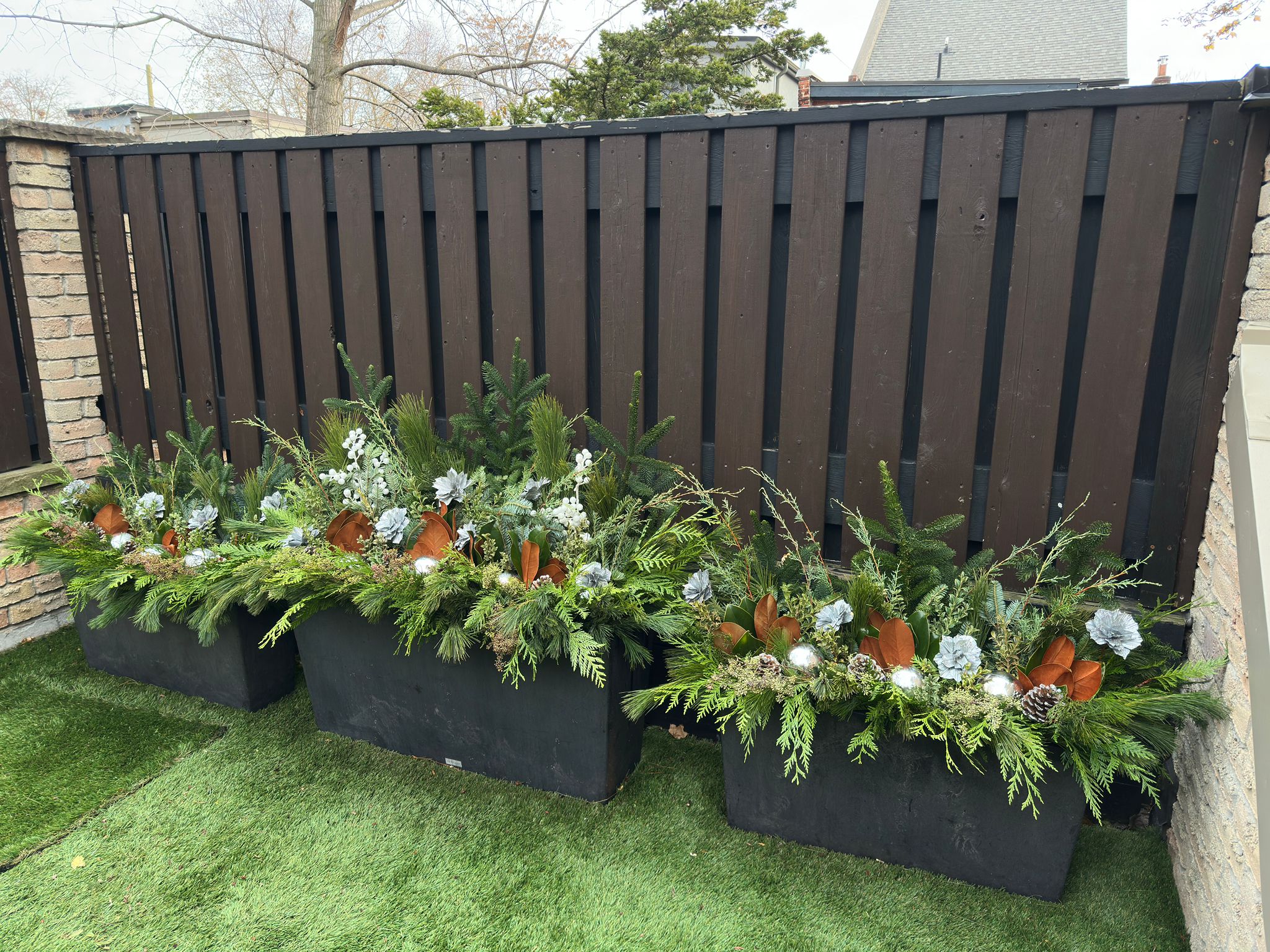 Decorative winter planters with evergreens and ornaments.