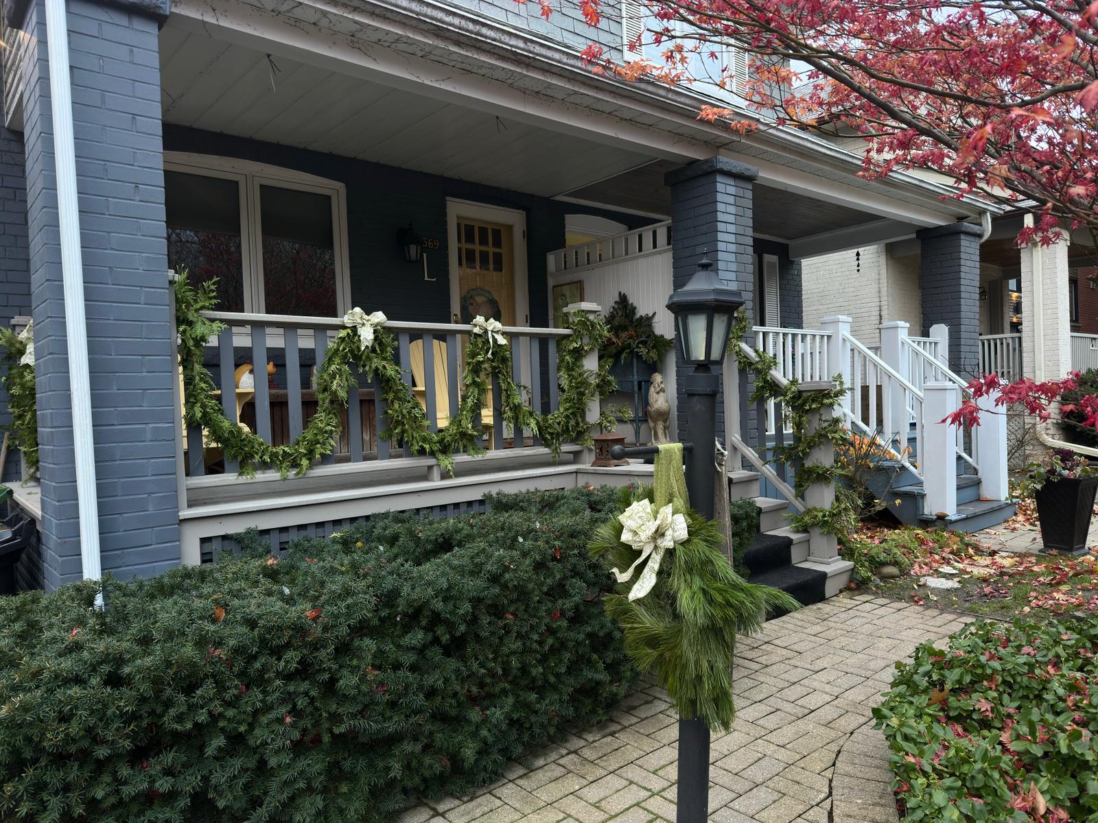 Festive porch with garland and autumn leaves.