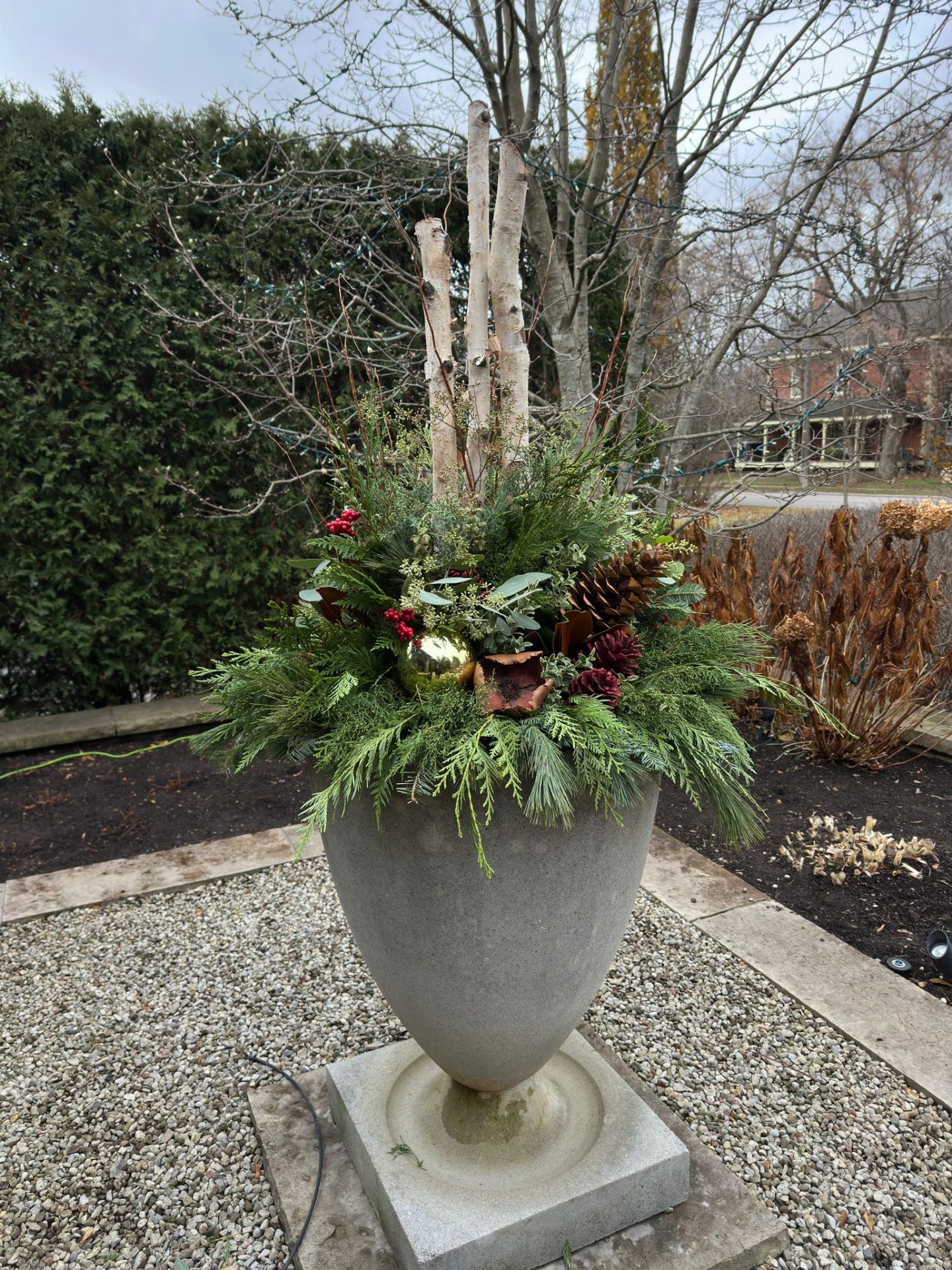 Large planter with winter greenery arrangement.