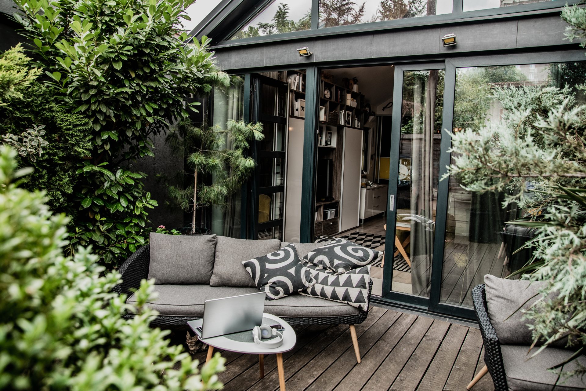 Cozy patio seating with laptop and cushions.