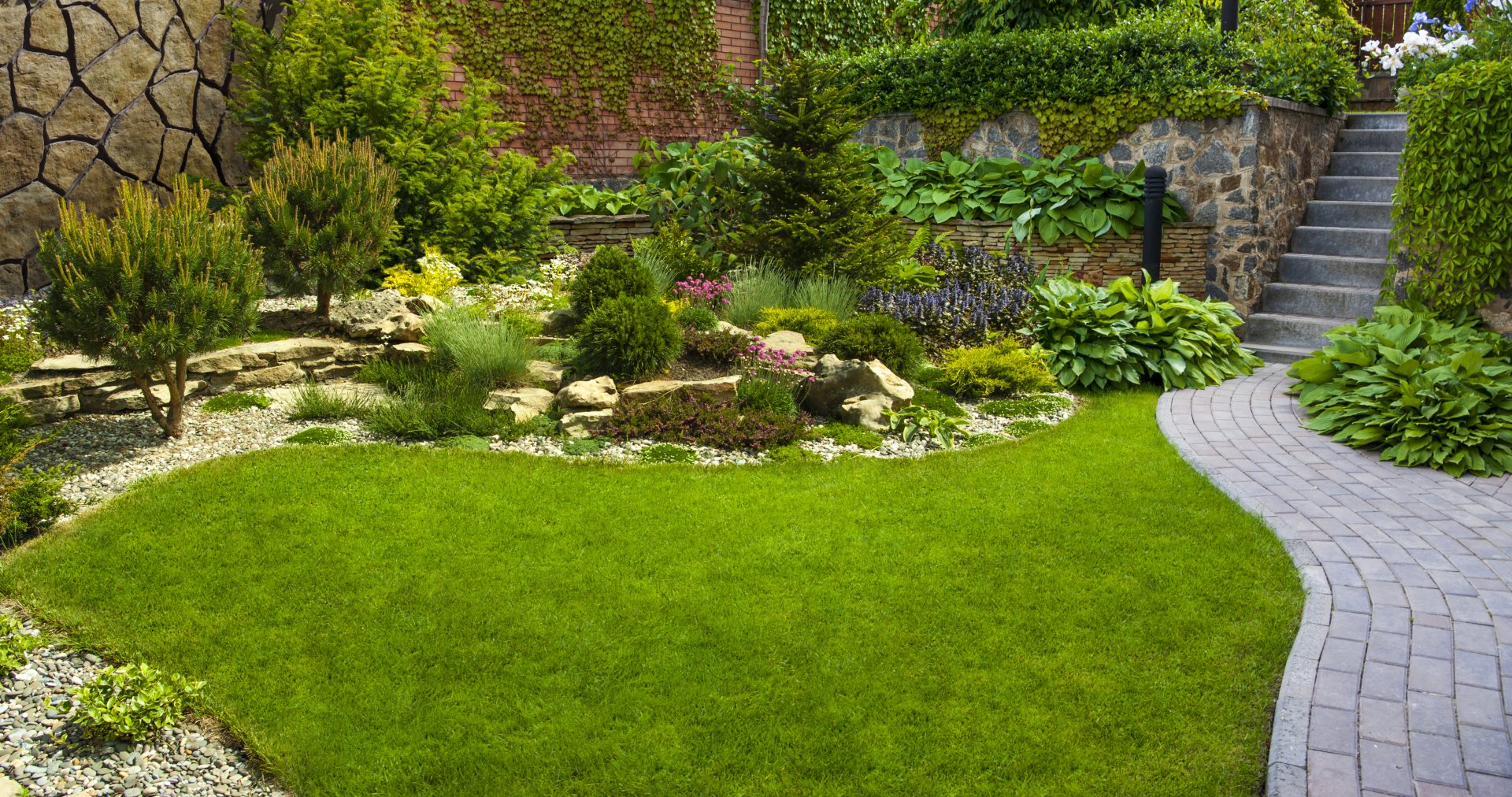 Beautiful landscaped garden with greenery and stone walkway.
