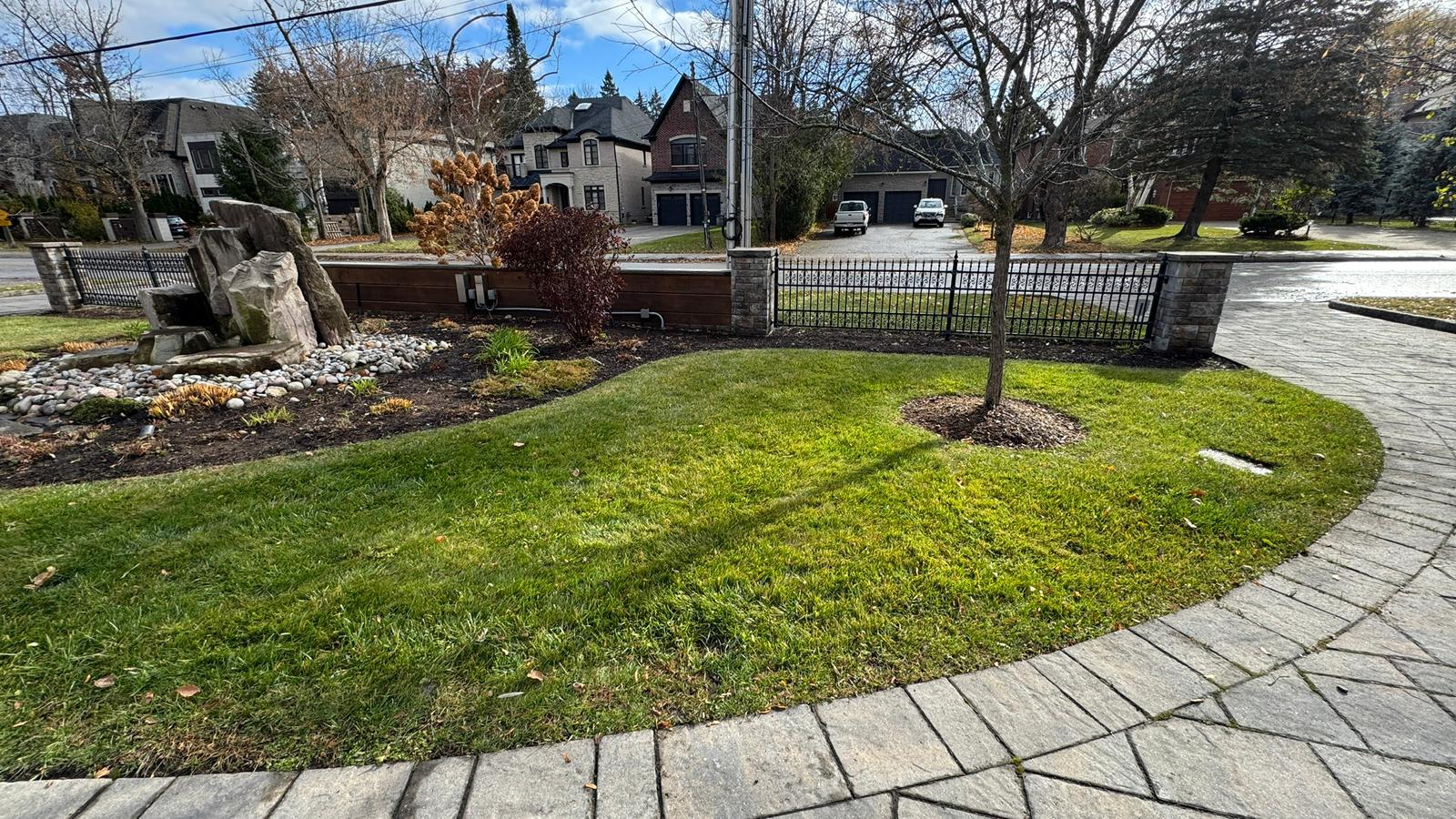 Suburban front yard with grass and stone feature.
