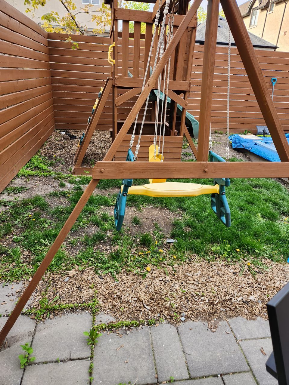 Backyard playground with wooden swing set.
